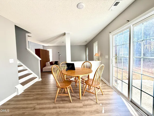 a view of a dining room with furniture wooden floor and windows