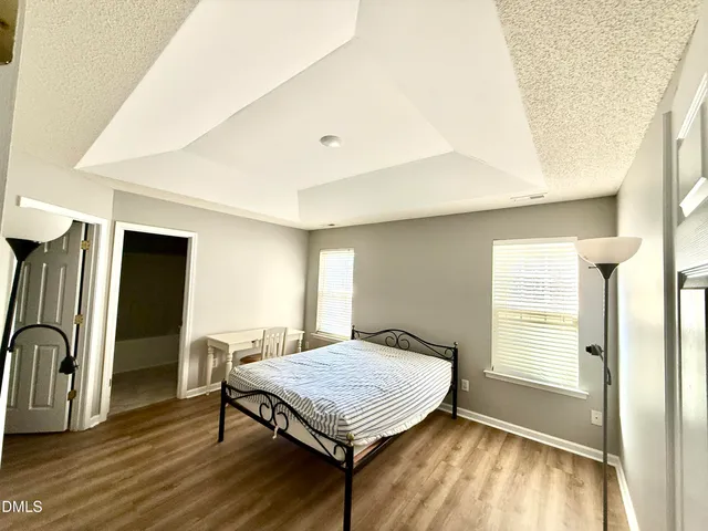 a living room with stainless steel appliances furniture a window and wooden floor