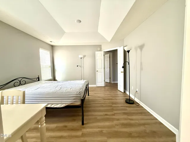 a bedroom with a bed table and a large mirror