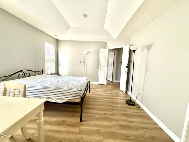 a bedroom with a bed and wooden floor