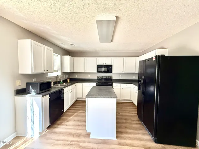 a kitchen with stainless steel appliances granite countertop a refrigerator a stove and a sink