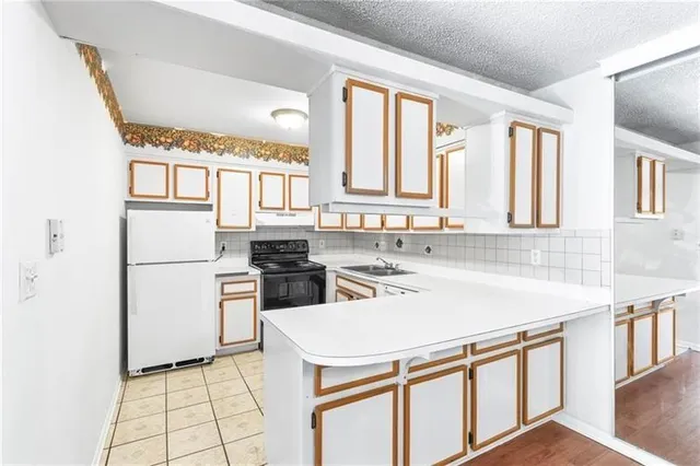 a kitchen with a sink a stove a refrigerator and a window
