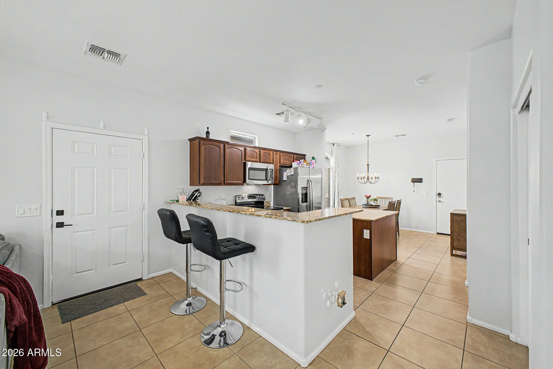 2725 East Mine Creek Road, Unit 1187 Phoenix, AZ 85024 - Photo 7 of 37 a kitchen with stainless steel appliances kitchen island granite countertop a refrigerator and a stove