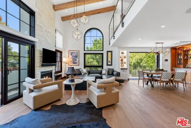 a living room with fireplace furniture wooden floor and a large window