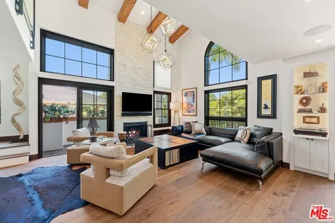 a living room with furniture flat screen tv and a large window