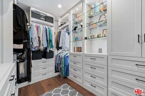 a view of walk in closet with clothes and shoes