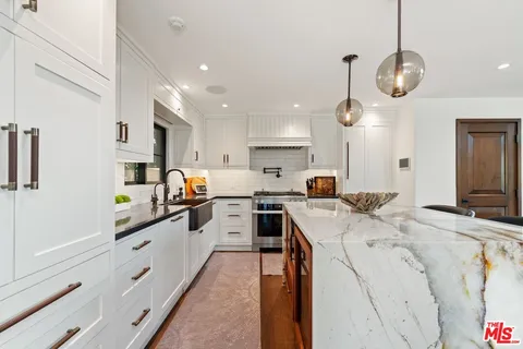 a kitchen with stainless steel appliances kitchen island granite countertop a sink and cabinets