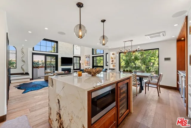 a large kitchen with stainless steel appliances granite countertop a stove a sink dishwasher and a fireplace with wooden floor