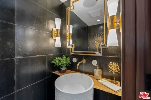 a bathroom with a granite countertop sink a toilet and mirror