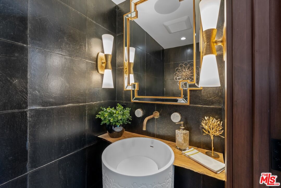 2612 Montana Avenue, Unit 1 Santa Monica, CA 90403 - Photo 8 of 27 a bathroom with a granite countertop sink a toilet and mirror