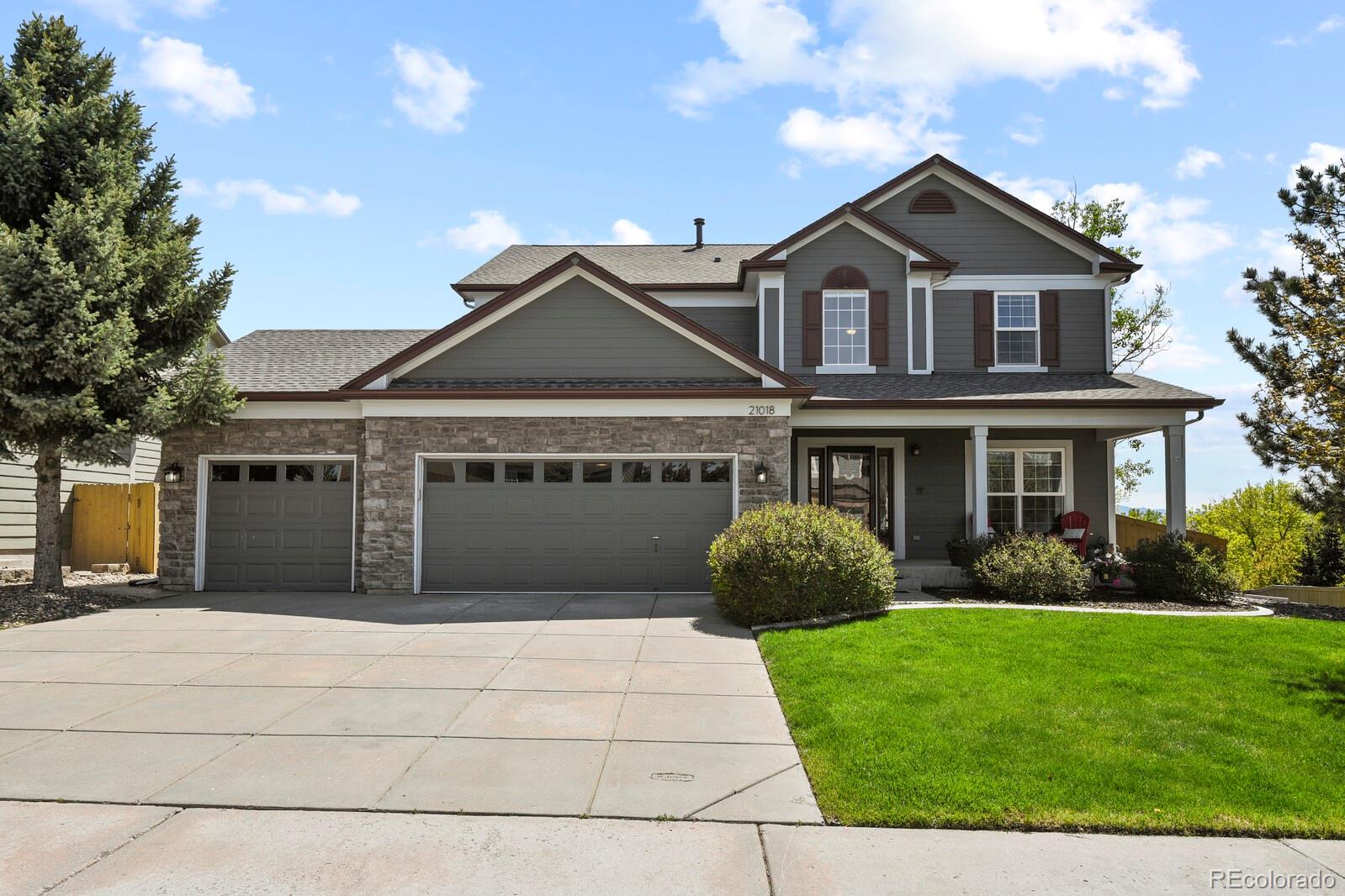 a front view of a house with a garden and plants