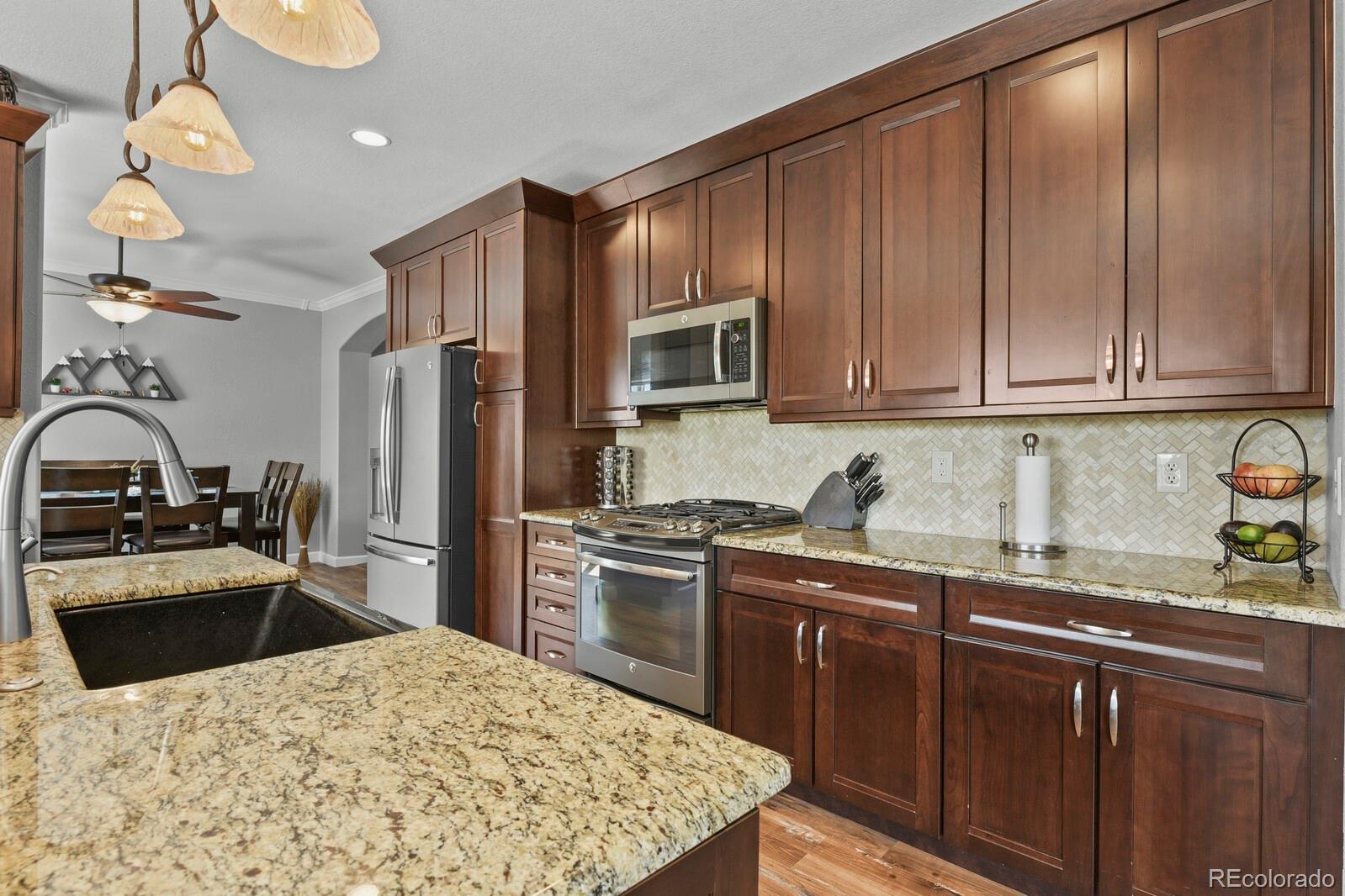 21018 Saddleback Circle Parker, CO 80138 - Photo 12 of 50 a kitchen with stainless steel appliances granite countertop a sink stove and refrigerator