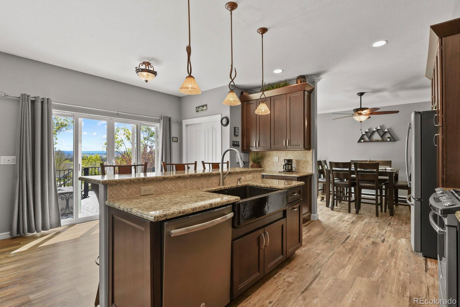 21018 Saddleback Circle Parker, CO 80138 - Photo 13 of 50 a kitchen with stainless steel appliances granite countertop a stove a sink and a wooden floors