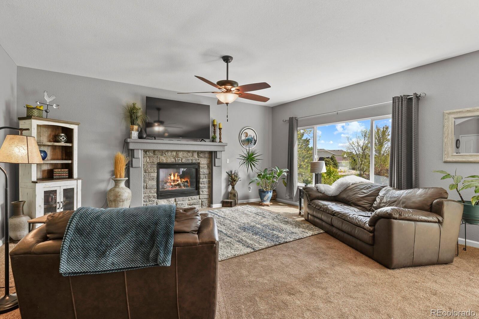 21018 Saddleback Circle Parker, CO 80138 - Photo 17 of 50 a living room with furniture a flat screen tv and a fireplace