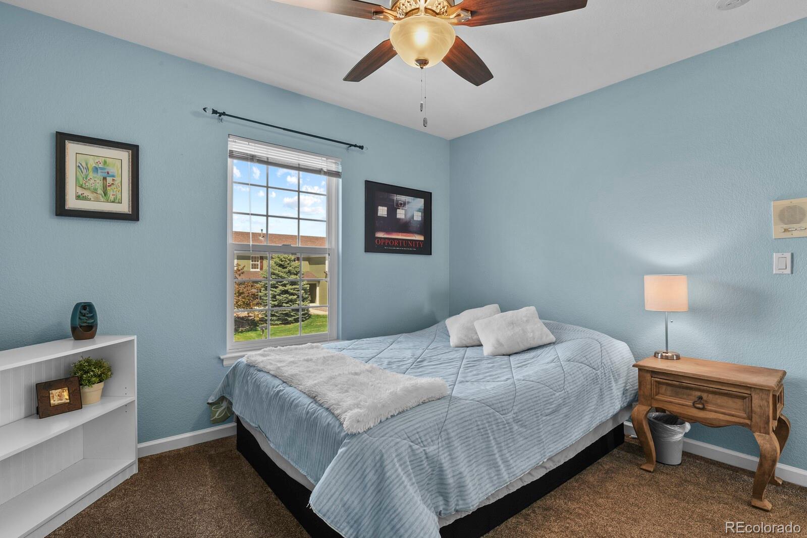 21018 Saddleback Circle Parker, CO 80138 - Photo 29 of 50 a bedroom with a bed and a lamp on dresser