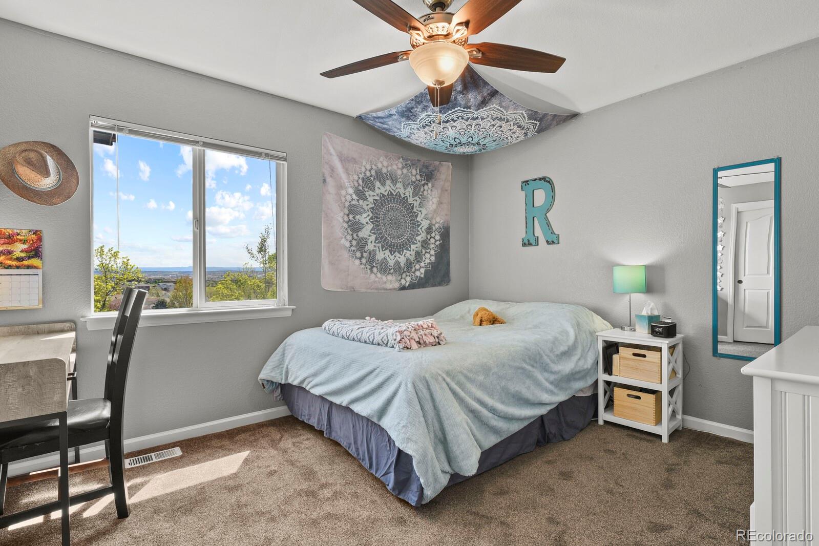 21018 Saddleback Circle Parker, CO 80138 - Photo 31 of 50 a bedroom with a bed and a chandelier