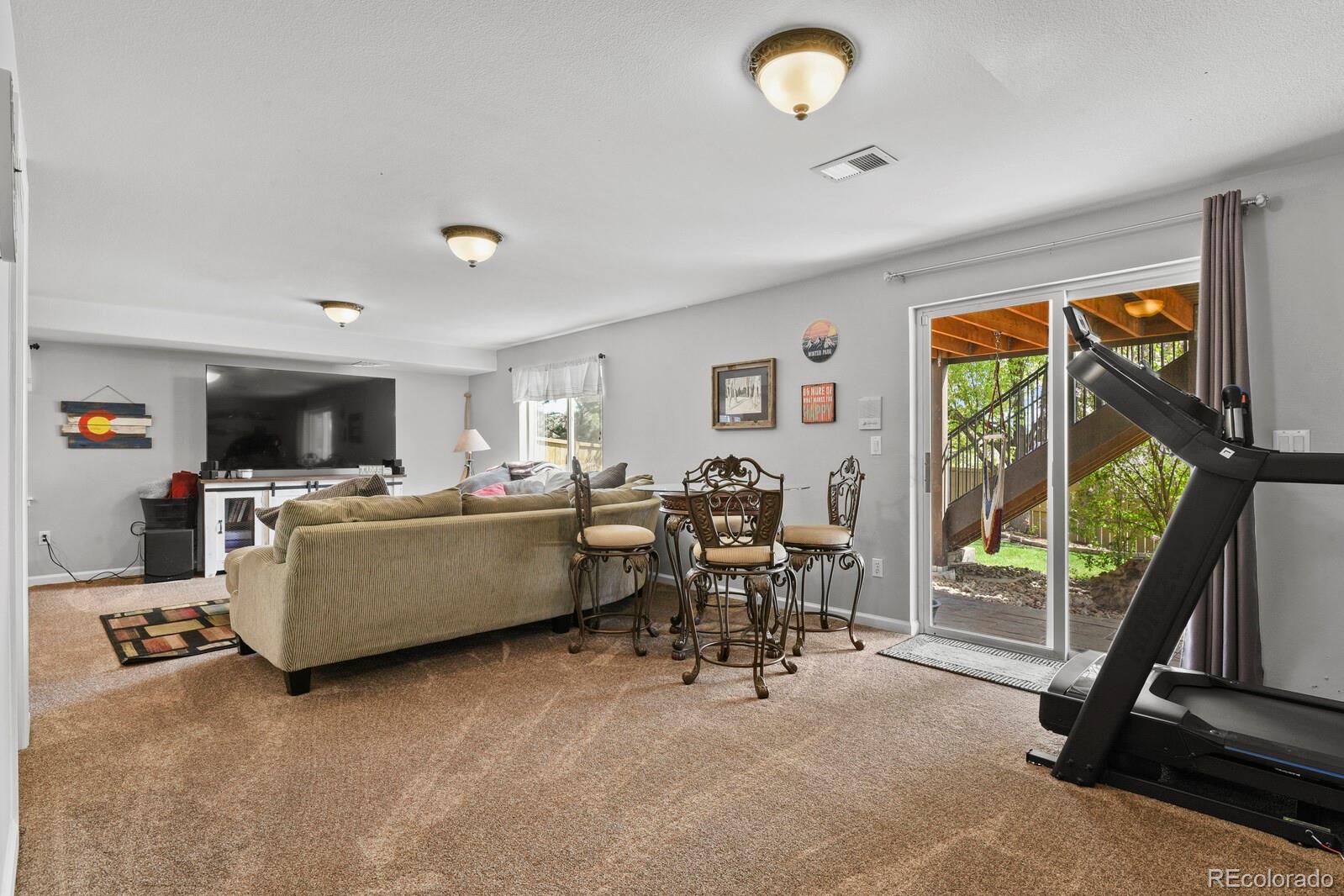 21018 Saddleback Circle Parker, CO 80138 - Photo 32 of 50 a living room with furniture a flat screen tv and a large window