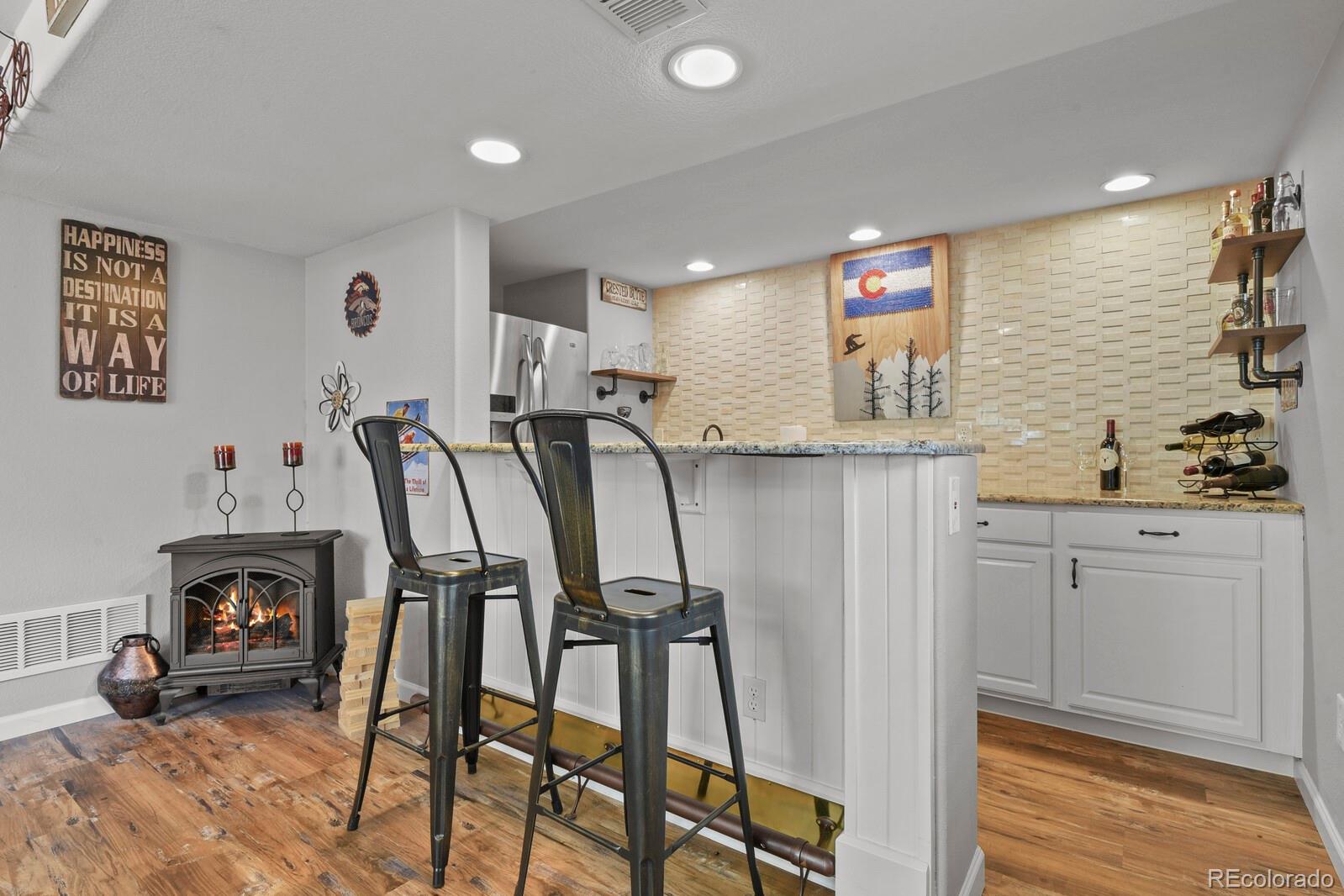 21018 Saddleback Circle Parker, CO 80138 - Photo 35 of 50 a view of a kitchen with kitchen island and stainless steel appliances wooden floor