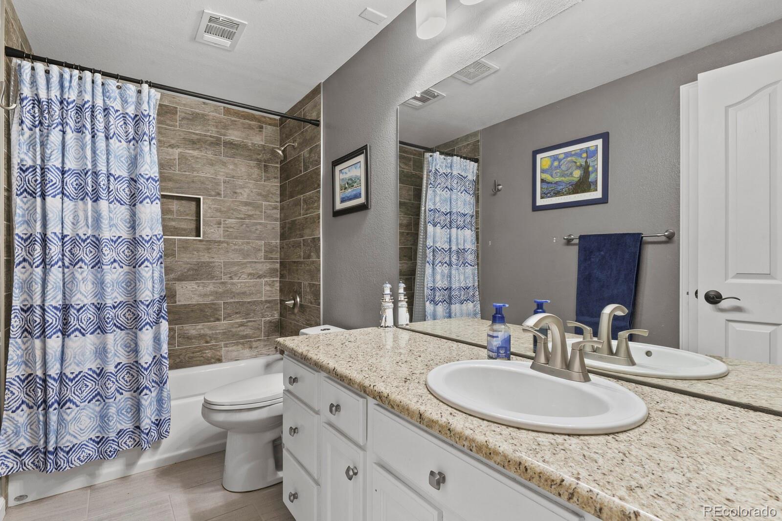 21018 Saddleback Circle Parker, CO 80138 - Photo 38 of 50 a bathroom with a granite countertop sink a toilet and a mirror