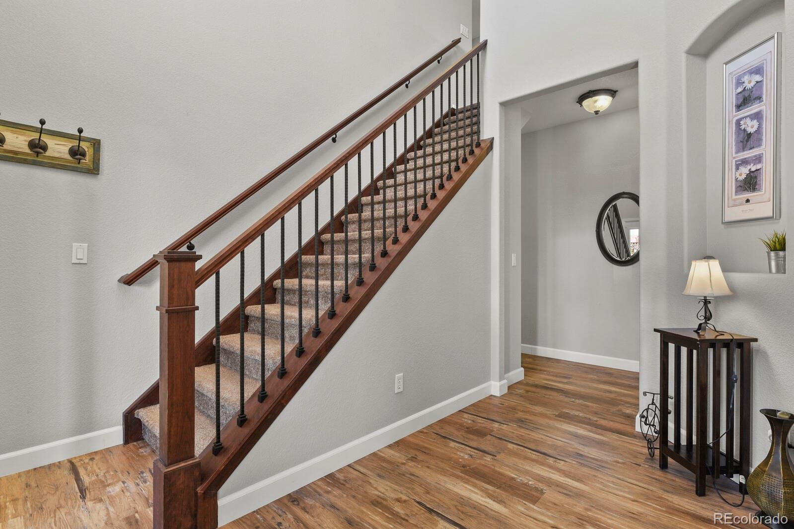 21018 Saddleback Circle Parker, CO 80138 - Photo 4 of 50 a view of a hallway with wooden floor and staircase
