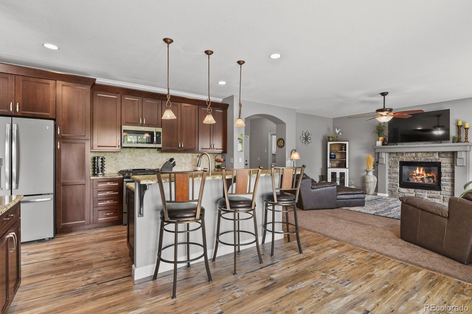 21018 Saddleback Circle Parker, CO 80138 - Photo 9 of 50 a view of kitchen with refrigerator stove microwave and wooden floor