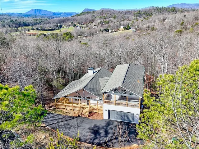 a view of a house with a yard balcony and wooden fence