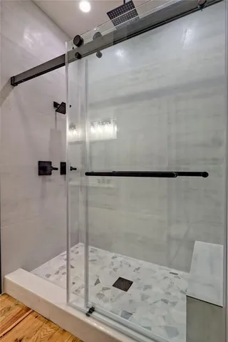 an empty room with wooden floor ceiling fan and windows