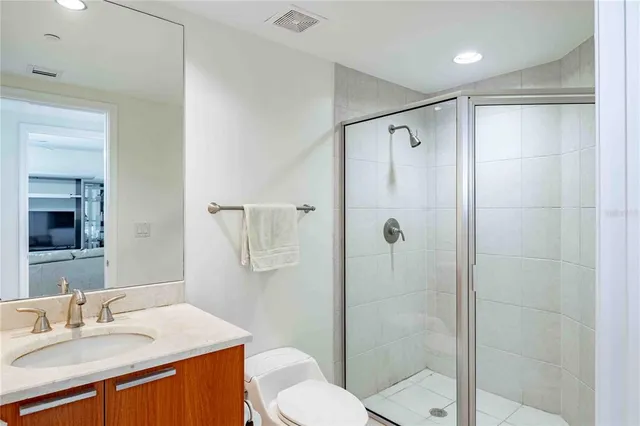 a bathroom with a granite countertop sink toilet and shower