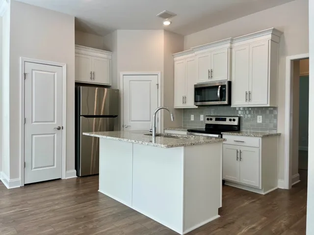 a kitchen with a sink and a stove top oven