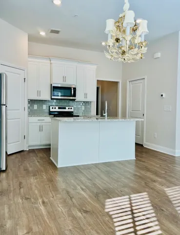 a kitchen with stainless steel appliances a stove a sink a microwave and cabinets