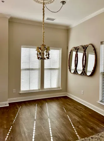 a view of a hallway with wooden floor and window