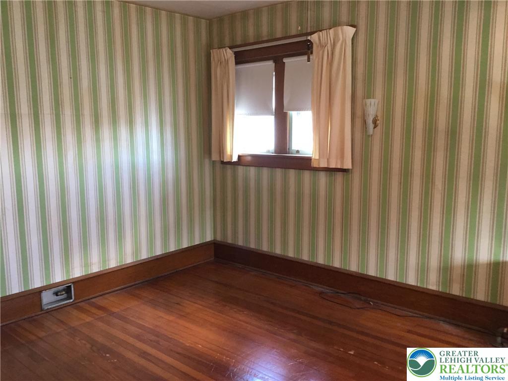 1105 Main Street Slatington, PA 18080 - Photo 21 of 31 Rich hardwood flooring complements a cheerful, naturally illuminated space with striped wall coverings.