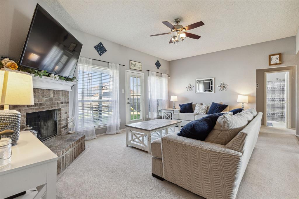 a living room with furniture a fireplace and a flat screen tv