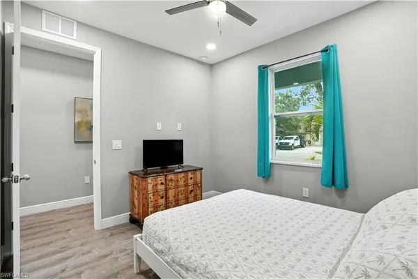 a bedroom with a bed and a flat tv screen on dresser