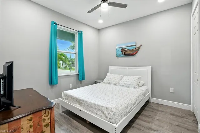 a bedroom with a bed and a flat tv screen on dresser