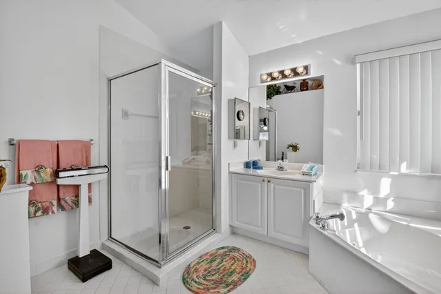 a view of a white house with a large window and potted plants