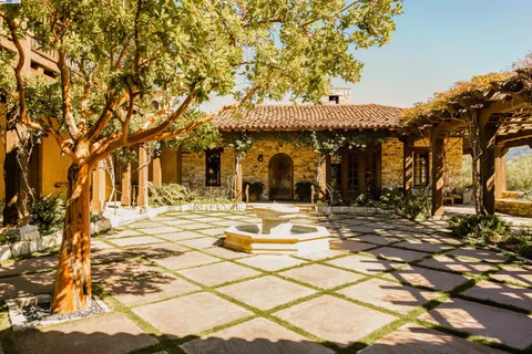 a view of a patio with a table and chairs under an umbrella