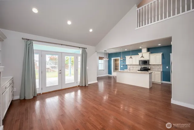 a view of kitchen with kitchen island wooden floor and stainless steel appliances