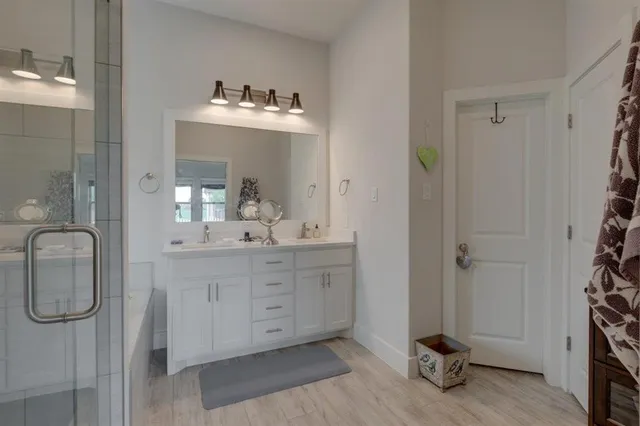 a bathroom with a double vanity sink mirror and shower