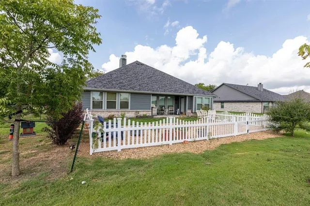 a front view of a house with a garden and yard