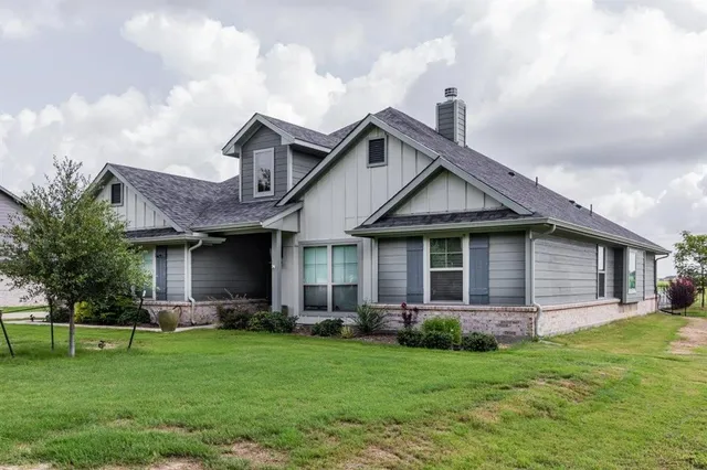 a front view of a house with a garden and yard