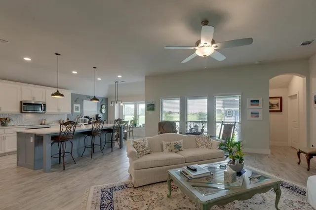 a living room with furniture kitchen view and a chandelier