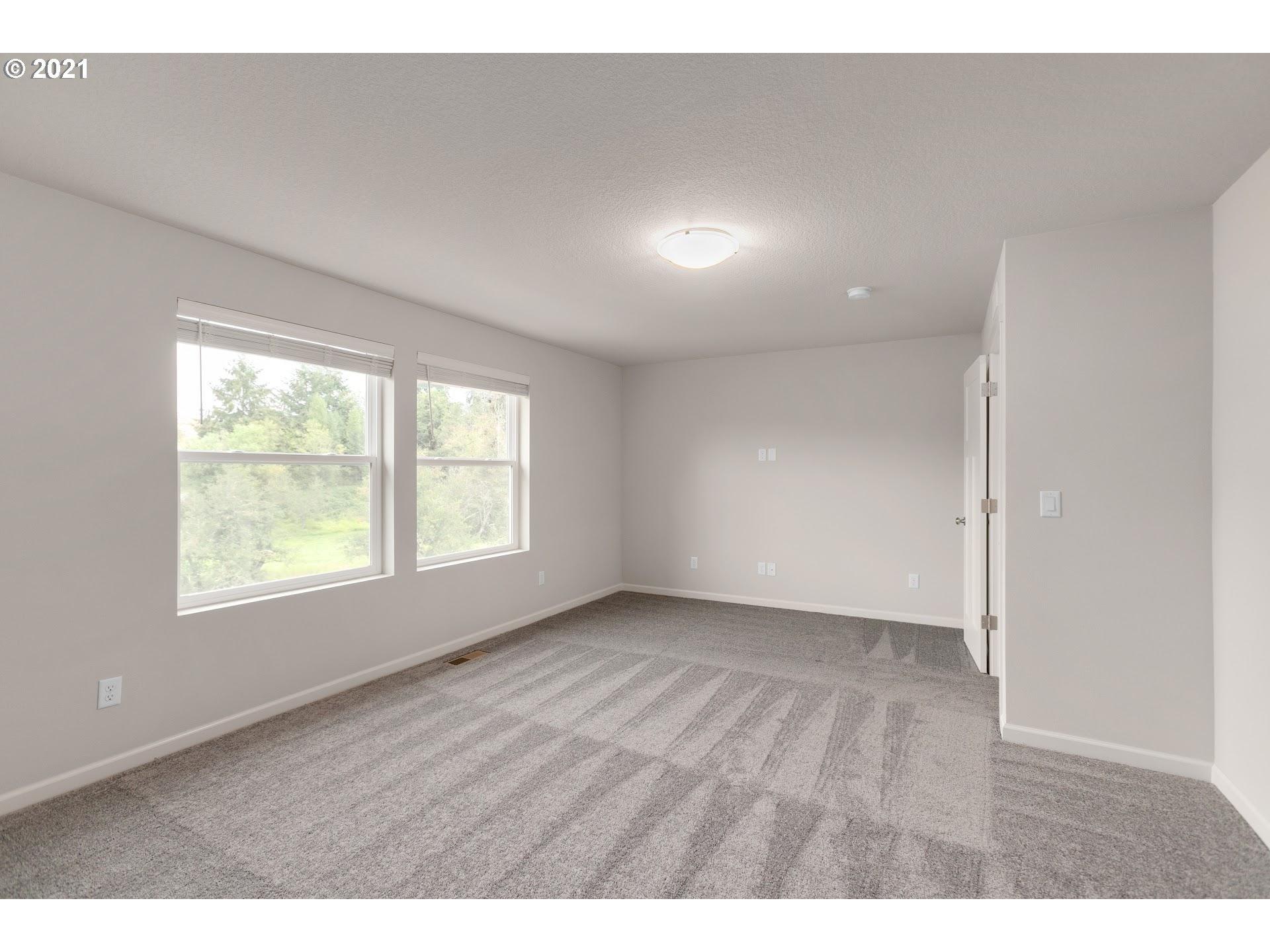 4243 South Waters Edge Way Ridgefield, WA 98642 - Photo 15 of 25 an empty room with wooden floor and windows