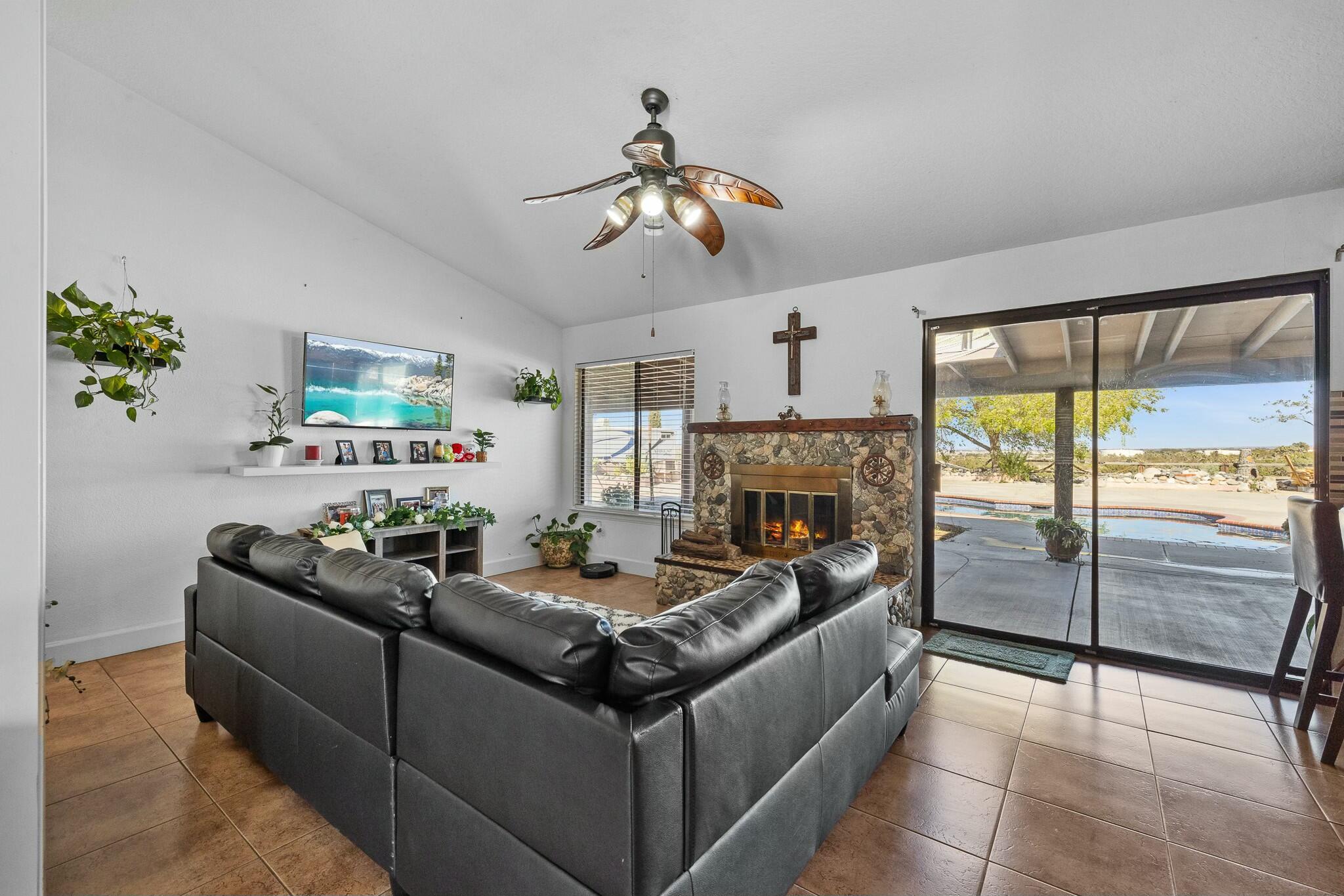 36070 43rd Street East Palmdale, CA 93552 - Photo 16 of 53 a living room with furniture a fireplace and a chandelier