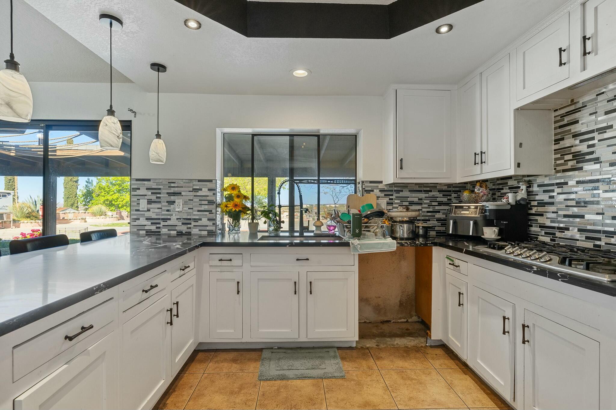 36070 43rd Street East Palmdale, CA 93552 - Photo 24 of 53 a kitchen with stainless steel appliances granite countertop a stove a sink and white cabinets
