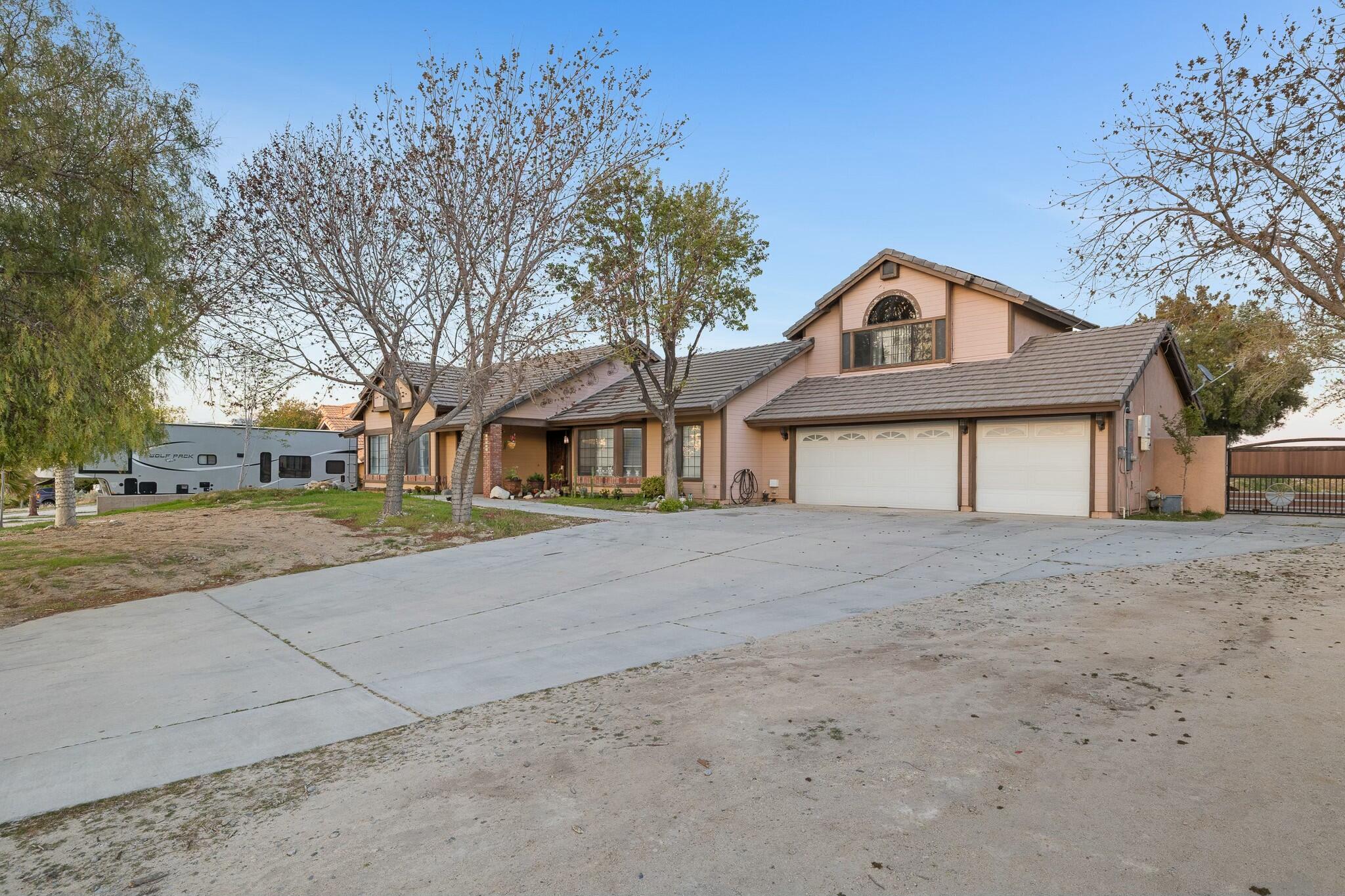 36070 43rd Street East Palmdale, CA 93552 - Photo 3 of 53 a front view of a house with a yard and garage