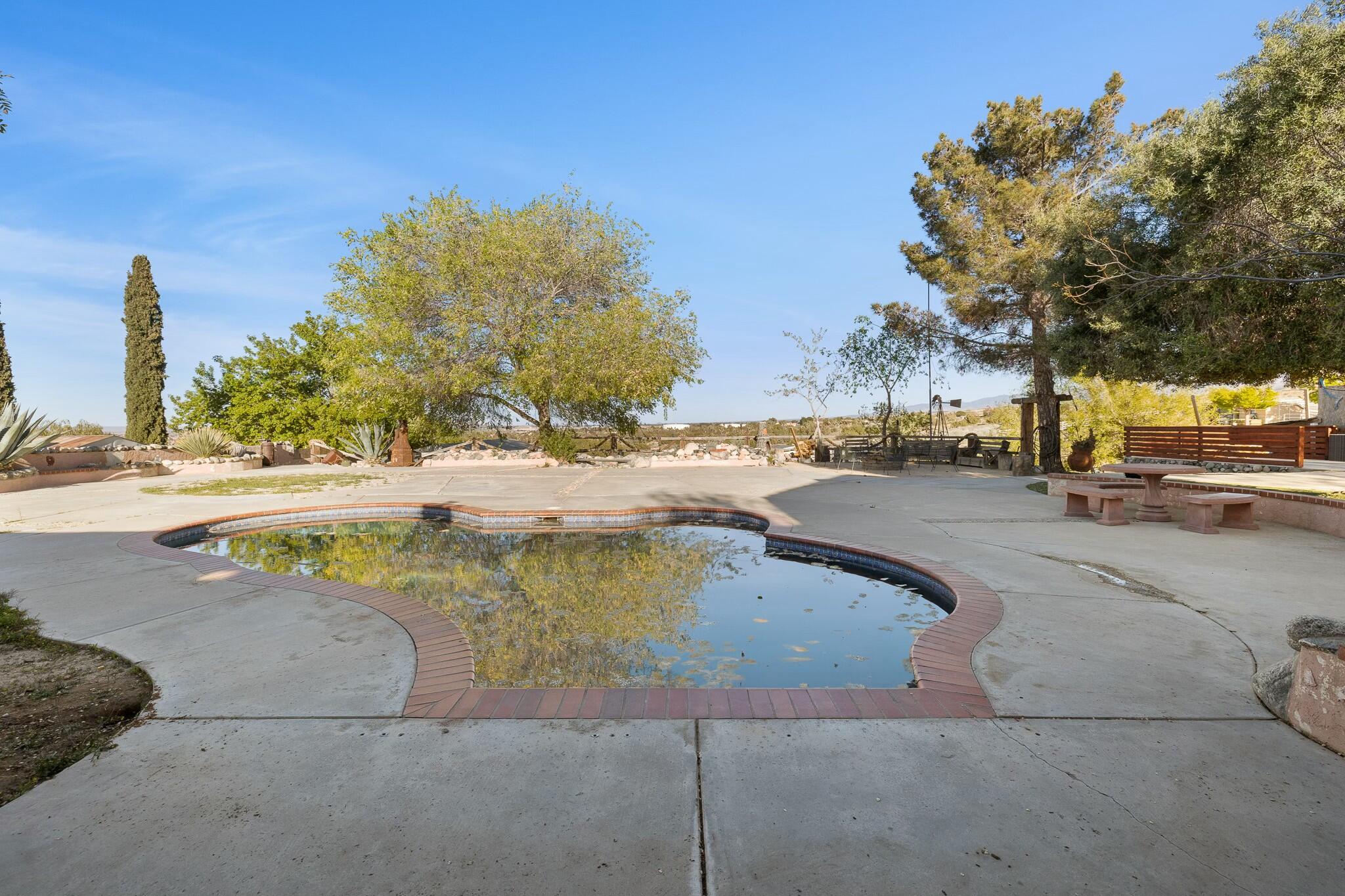 36070 43rd Street East Palmdale, CA 93552 - Photo 46 of 53 a view of a swimming pool with a lawn chairs and a fire pit