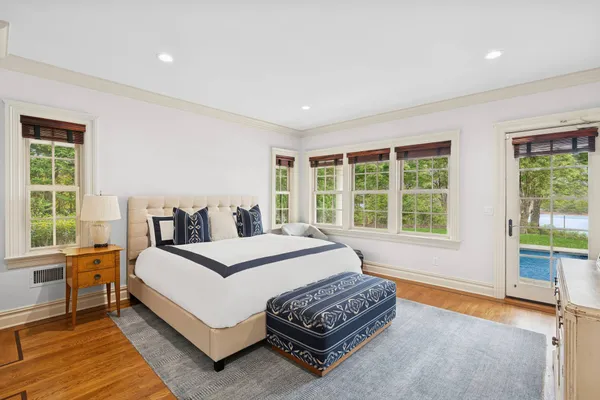 a bedroom with a bed lamp and a large window