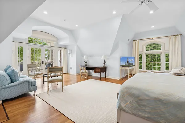 a large bedroom with a large bed and large windows