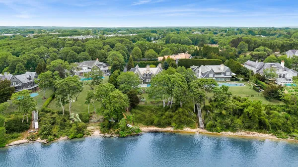 an aerial view of residential houses with outdoor space and trees